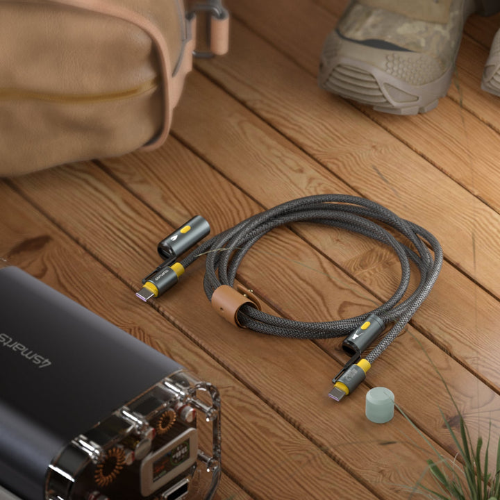 4smarts 3-in-1 USB-C Explorer Kabel aufgerollt mit Lederband, neben einer Powerbank, zeigt Tragbarkeit und Outdoor-Funktionalität.